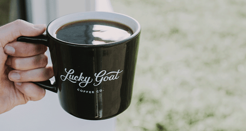 Person holding a cup of Lucky Goat drip coffee.